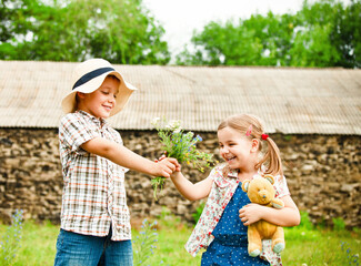 Little boy gives flowers to the little girl