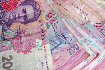 Ukrainian money is portrayed in all its richness through a close-up photo of a stack of Hryvnia banknotes, featuring a variety of denominations and their distinctive colors.
