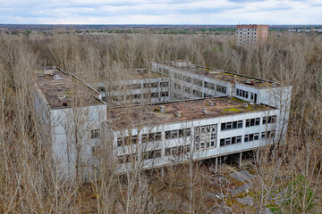 Decaying architecture amidst barren trees, evidence of neglect.