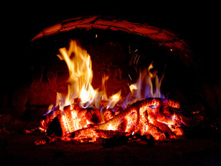 A fire burns brightly, illuminating the dark surroundings with its intense flames.
