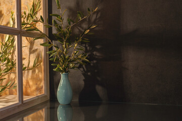 Panorama de fond d'un mur noir avec un vase et des branches d'oliviers pour création d'arrière...