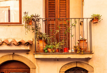 view of medeterranean street with vintage buildings , beautiful windows and picturesque balcony with attributes of traditional italian country life