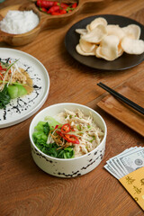 Foods to eat on Lunar New Year’s Eve on the table with golden envelope stuffed with money as a token of good fortune in the New Year.