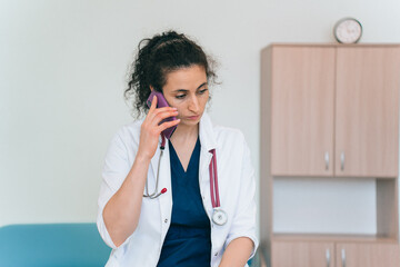 Doctor in white coat talking on the phone in clinic