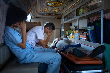 Team of paramedic is sitting in the ambulance in grief as they are too late to save the patient life from car accident for emergency case and unsuccessful life rescue mission © Akarawut