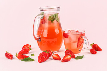 Glass cup and jug of tasty strawberry drink on white background