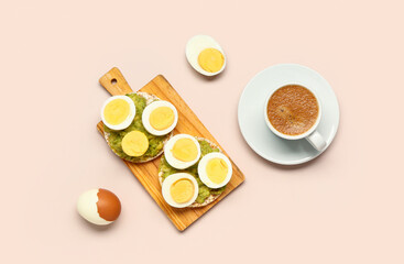 Wooden board of rice crackers with boiled eggs and avocado on pink background