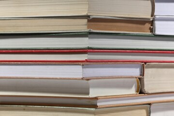 Stack of many different hardcover books as background, closeup