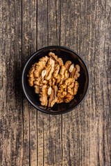 Peeled dried walnut kernels in bowl. Top view.
