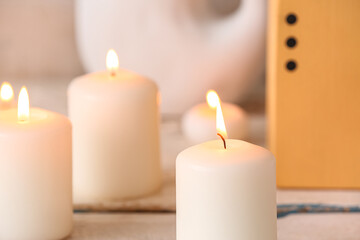 Fototapeta na wymiar Burning candles on white wooden background
