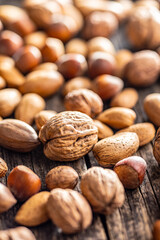 A mix of different nuts on wooden table.