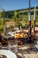 hairs and a table for guests, decorated with candles, are served with cutlery and crockery