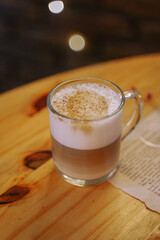beautiful cappuccino in a glass mug inside a cozy café
