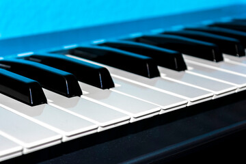 White and black keys of a keyboard with blue background.