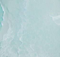 Obraz premium abstract white sand beach with transparent water wave from above, calm rippled water surface background concept with space for text or product presentation