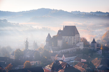 Biertan, Transylvania. Autumn sunsrise landscape with medieval saxon fortified church in Romania. - obrazy, fototapety, plakaty