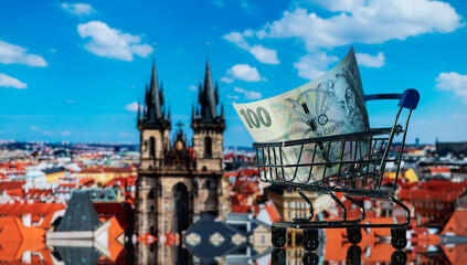A 100 Czech crown banknote in a miniature shopping cart against the backdrop of the landmarks of the city of Prague - obrazy, fototapety, plakaty