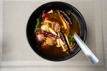 Top view of Tom Yum Pork and spicy soup.Food of Thailand consists of pork, dried chilies, tomatoes,...