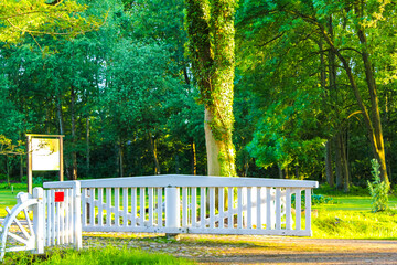 White fence and revolving gate in forest park in Germany.