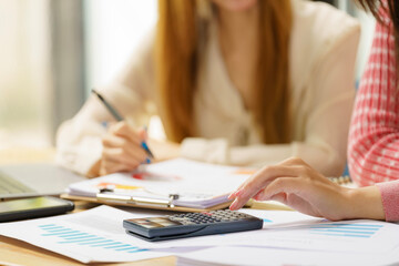 Close-up portrait of businesswoman accountant using calculator and laptop for matching financial...