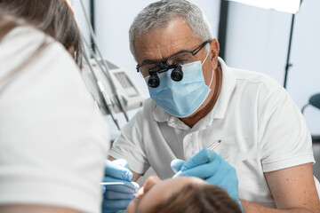 The physician and his assistant work as an outcome-oriented duo aimed at achieving optimal results in the treatment and restoration of oral health. - obrazy, fototapety, plakaty