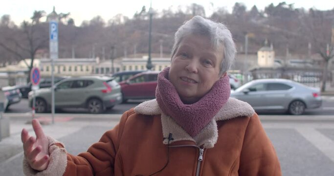 Mature Woman Shares Insights in City Interview. Experienced and eloquent woman shares her perspective. Cars background.