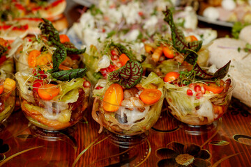 portioned vegetable salad in the foreground of the table with assorted food