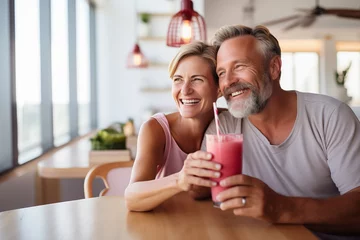 Fototapeten Middle aged couple at indoors with strawberry milkshake © luismolinero