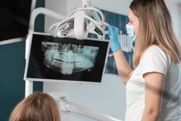 A dentist who provides high-quality dental care to her patients with great care and care. In her office, she creates an atmosphere of mutual understanding and cooperation. X-ray CT scan - obrazy, fototapety, plakaty