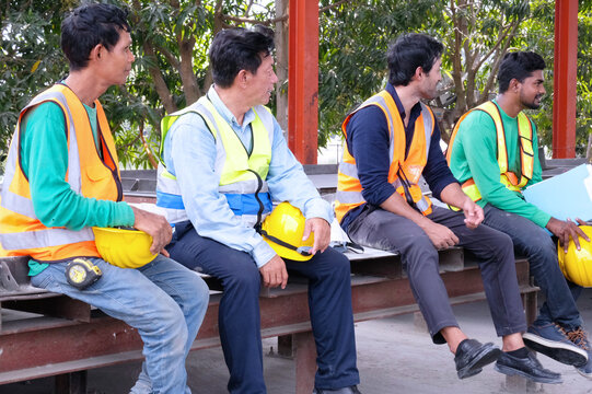 Workers sit and take a break from work at a construction site.
