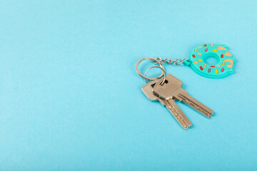 Donut shaped keychain with key ring on a colored background. Concepts for real estate and moving...