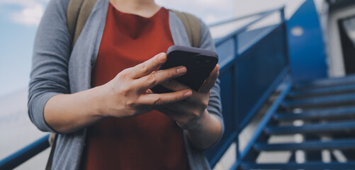 Blonde female tourist checking incoming notification on smartphone sitting on seat of airplane with...