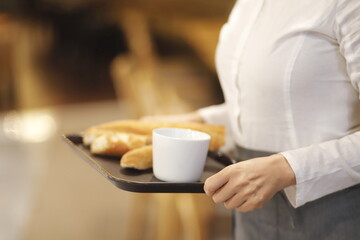 Waitress holding serving tray in cafe