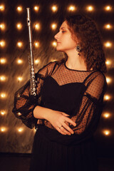 The flautist performed a happy musical piece on the black stage at the concert.