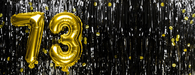 Gold foil balloon number number 73 on a background of black tinsel decoration. Birthday greeting...