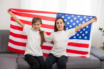 Two sisters with American flag on grey background