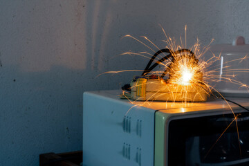 An electric shork from a microwave outlet causes a spark. Dangerous concept of using old electrical...