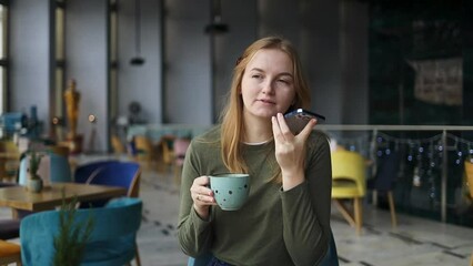 Relax, coffee and positive woman is recording audio message on mobile phone sitting on a couch in the city cafe. Youth and technology concept. 