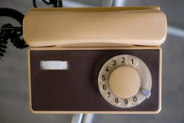 Old beige and brown telephone. The five-digit phone number is written on the device panel. Top view.