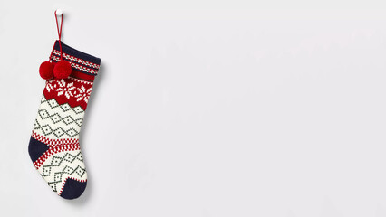 Colorful Christmas sock hanging on white copy-space background.