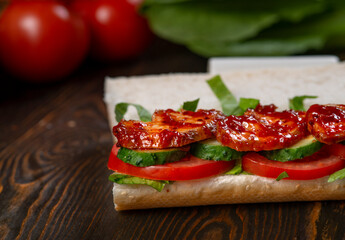Sandwich with grilled chicken, lettuce, tomatoes and black olives