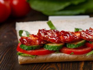 Sandwich with grilled chicken, lettuce, tomatoes and black olives