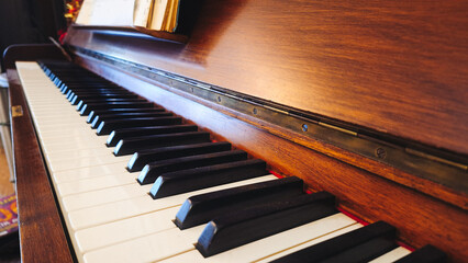 Close-up of black and white keys of an old wooden piano. Vintage piano keyboard, selective focus,...