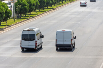 White modern delivery small shipment cargo courier van moving fast on motorway road to city urban...