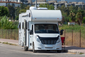 Mobile home on wheels van parked in the street of the city on the side of the road.