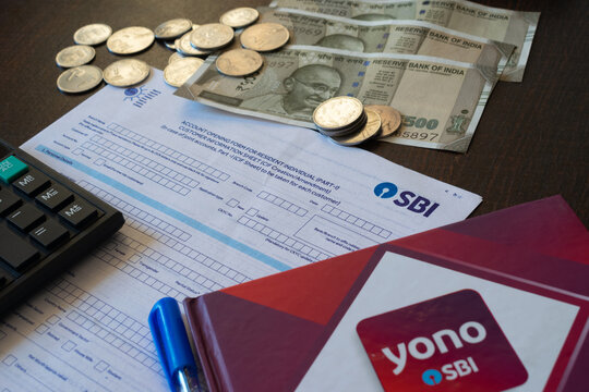 Picture of State Bank of India's account opening form along with cash, calculator, YONO brand and pen.
