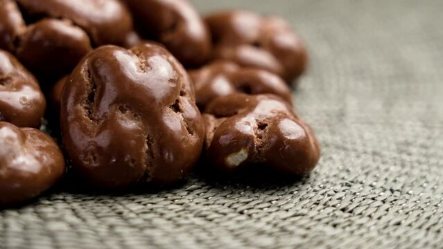 Glazed chocolate nut candies. Whole walnut dragee. Rotation