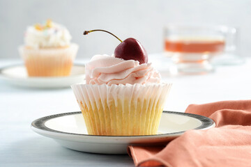 closeup cherry buttercream cupcake on plate - 704492283