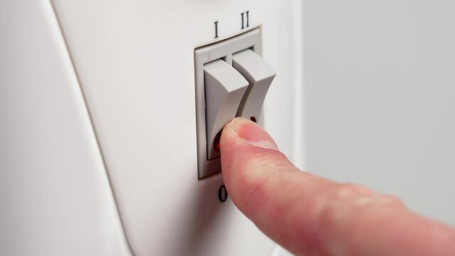 Turning off the indoor electric heater by clicking the switch down close up