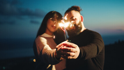 Couple with sparkle candle outdoor in the night